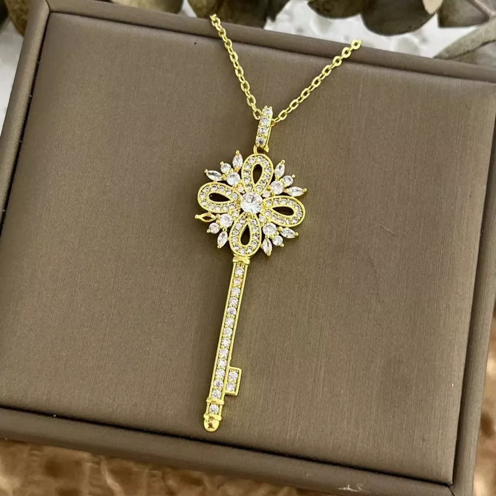Gold-plated key pendant necklace with crystal accents and a delicate chain.