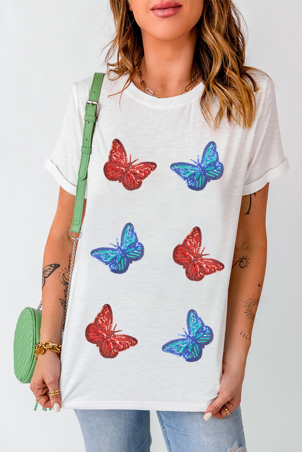 White t-shirt with embroidered red and blue butterfly motifs