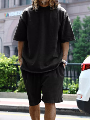Men's black relaxed fit two-piece set with drawstring shorts and short sleeve tee.