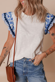 White tee with blue floral embroidered flutter sleeves and striped trim.