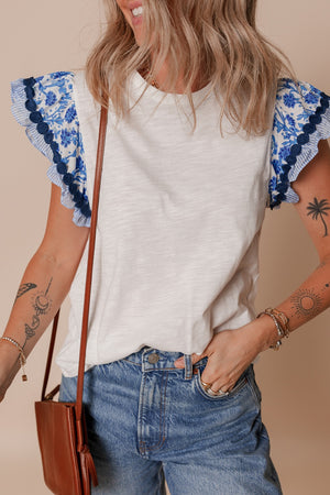 White tee with blue floral embroidered flutter sleeves and striped trim.