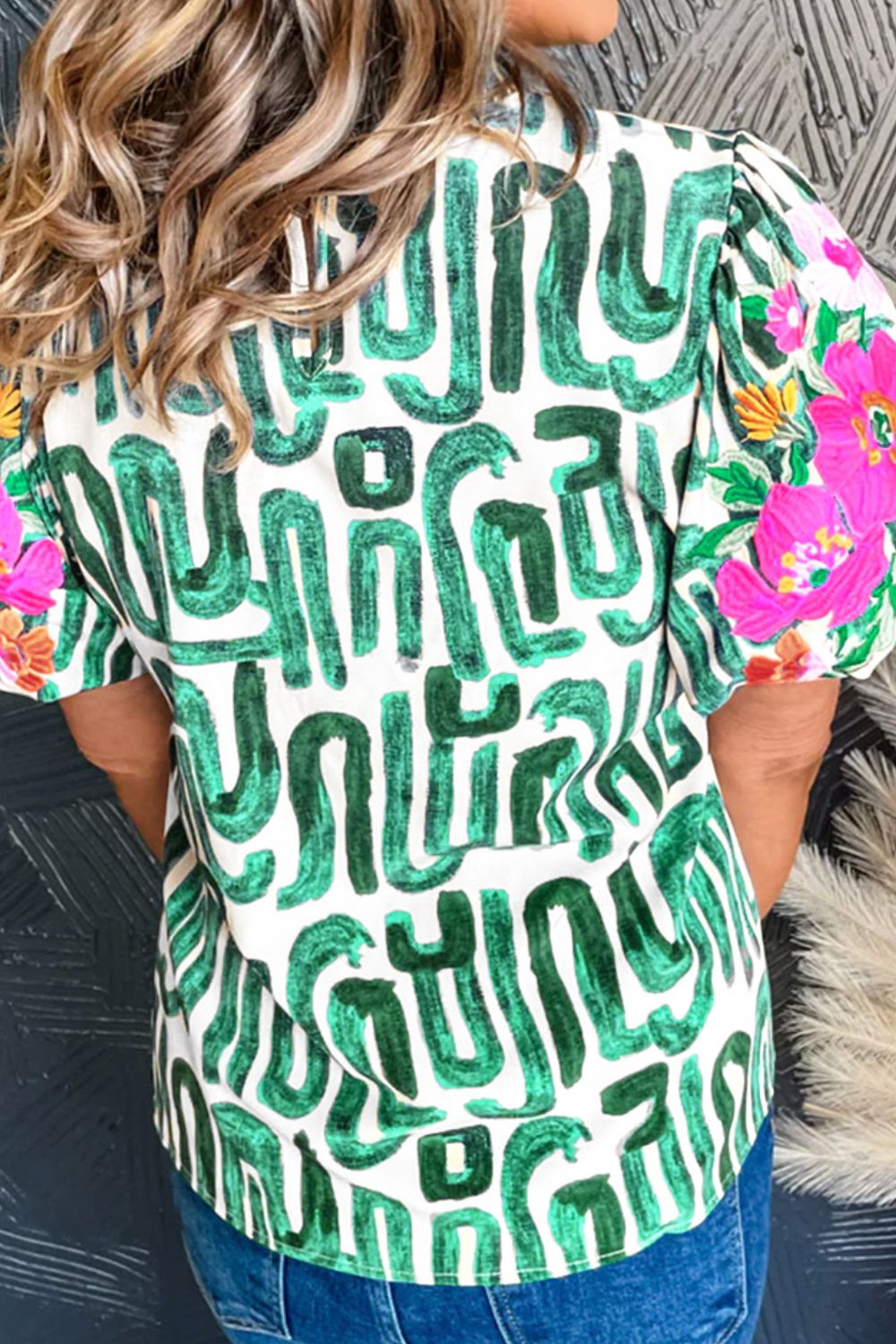 Abstract print puff sleeve top in white with green brushstroke pattern and floral sleeves.
