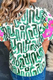 Abstract print puff sleeve top in white with green brushstroke pattern and floral sleeves.