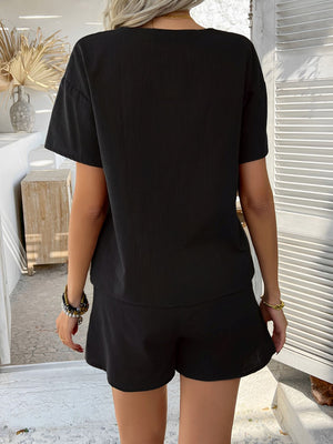 Black linen tie-front top and shorts set with short sleeves and a relaxed fit.