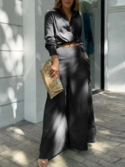Black two-piece set with pocketed wide-leg pants and a collared crop top.