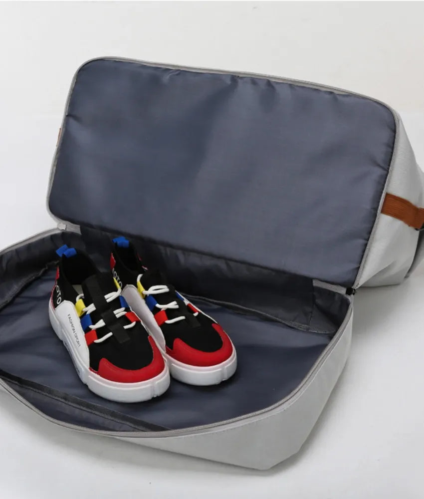 Gray dual-compartment weekender bag with colorful sneakers inside