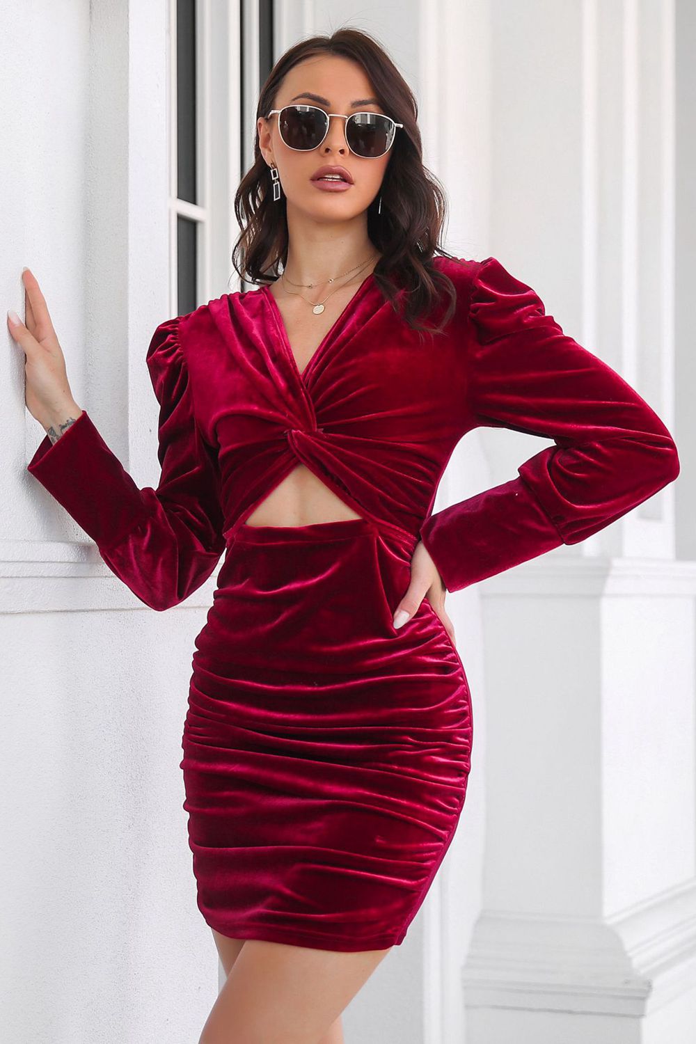 Burgundy velvet ruched mini dress with twist-front and cut-out detail.