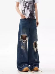 Distressed wide-leg jeans in blue denim with large rips and raw hems.