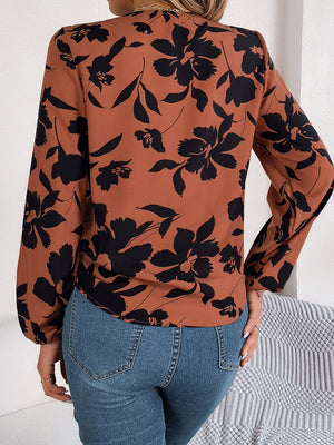 Brown floral knot-front blouse with long sleeves and ruffled cuffs.