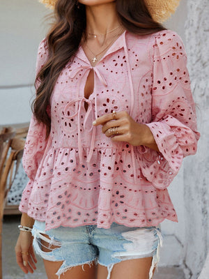 Dusty pink eyelet embroidered peplum blouse with tie neck and bell sleeves.