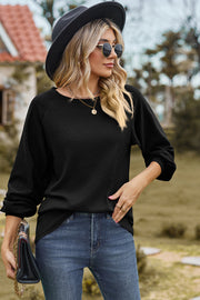 Black waffle knit eyelet raglan sleeve top with crew neck and casual fit.
