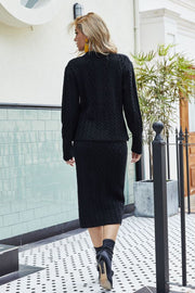 Black cable knit cardigan and pencil skirt set with long sleeves and crew neck.