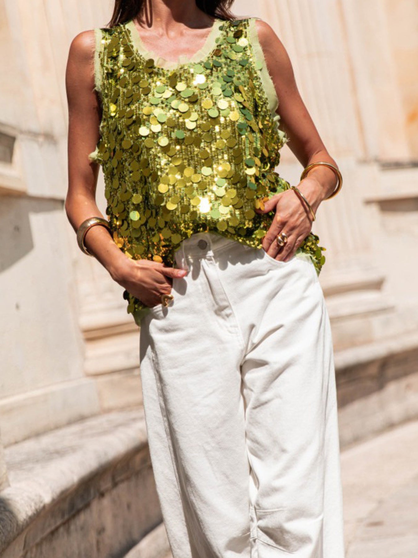 Light Green sequin tank top with frayed neckline and armholes, styled with white pants.
