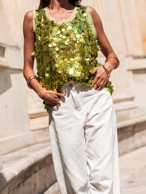Light Green sequin tank top with frayed neckline and armholes, styled with white pants.
