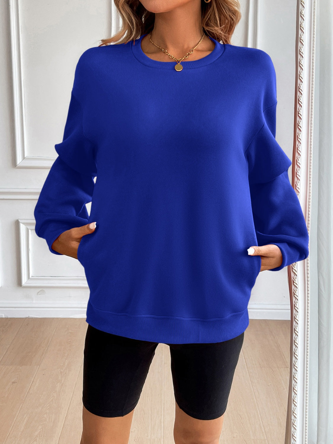 Relaxed fit royal blue sweatshirt with crewneck, long sleeves, and side pockets.