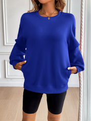 Relaxed fit royal blue sweatshirt with crewneck, long sleeves, and side pockets.