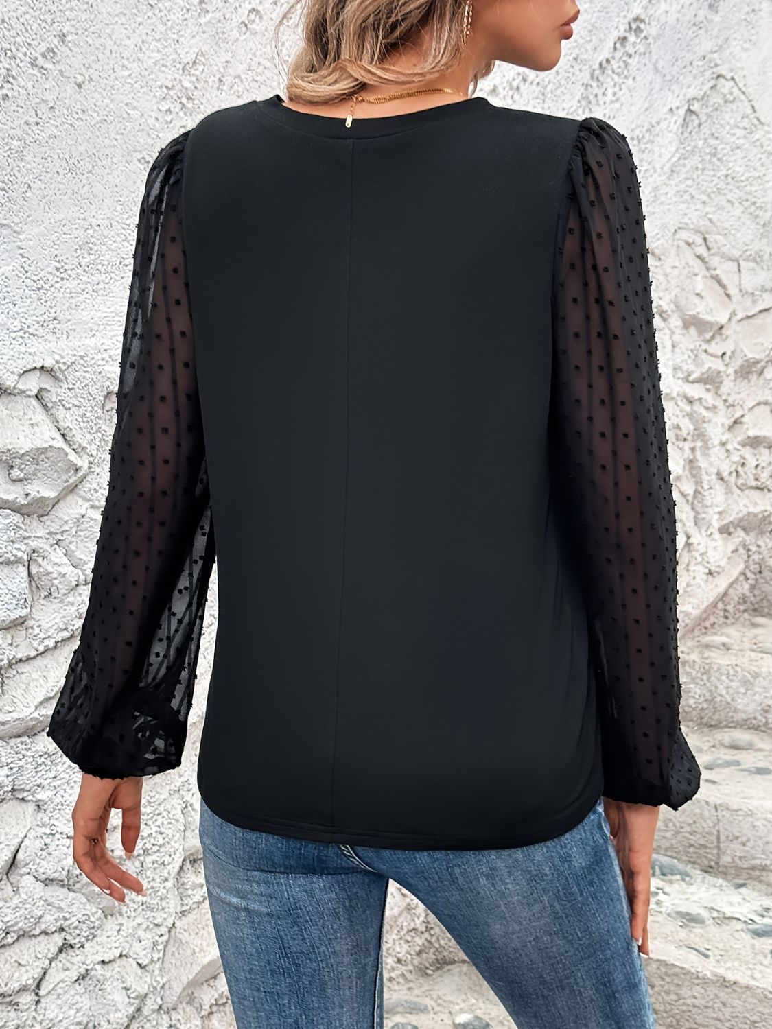 Black blouse with sheer dot puff sleeves and V-neck.