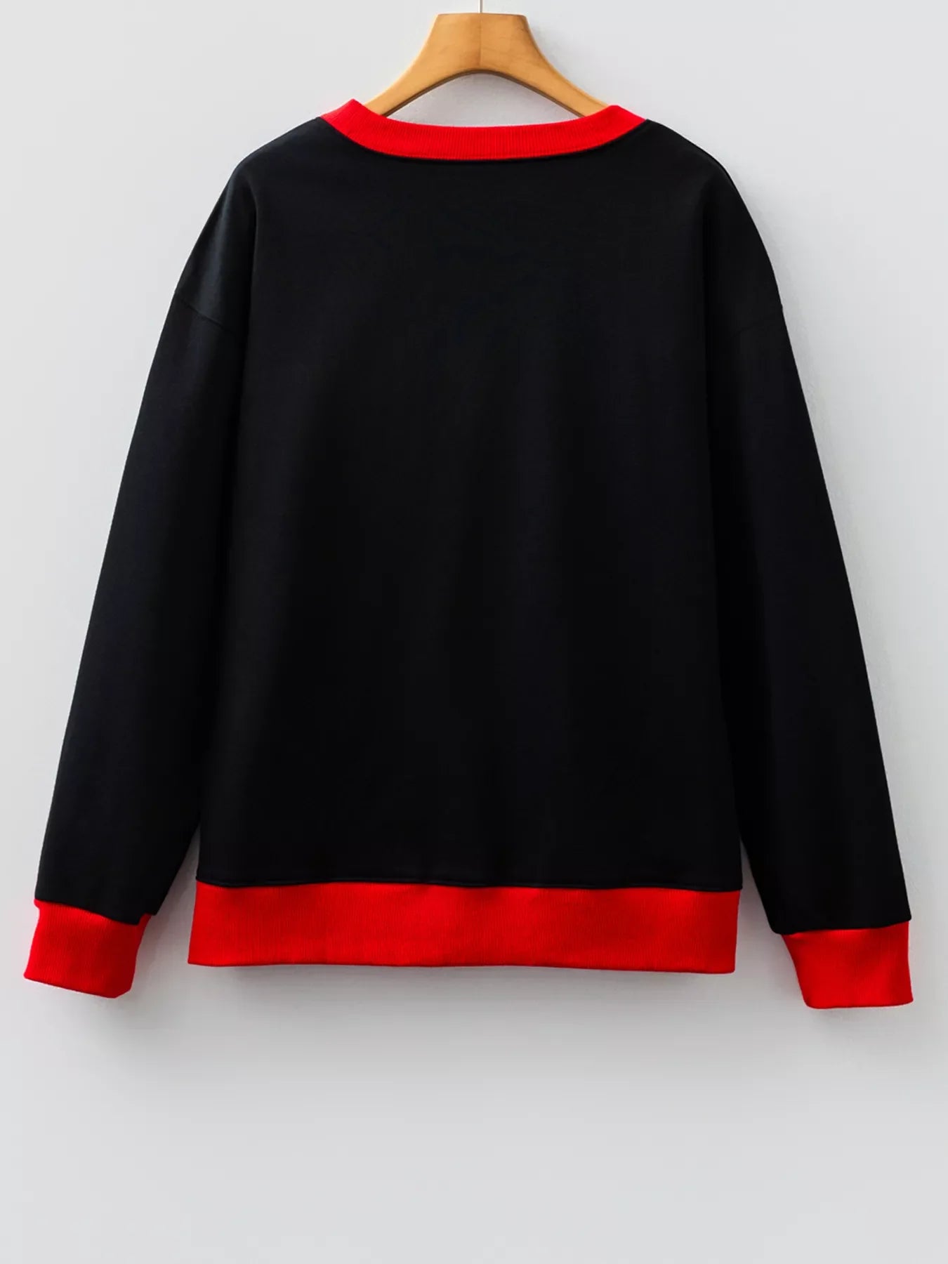 Black sweatshirt with red collar and cuffs, comfortable casual wear.
