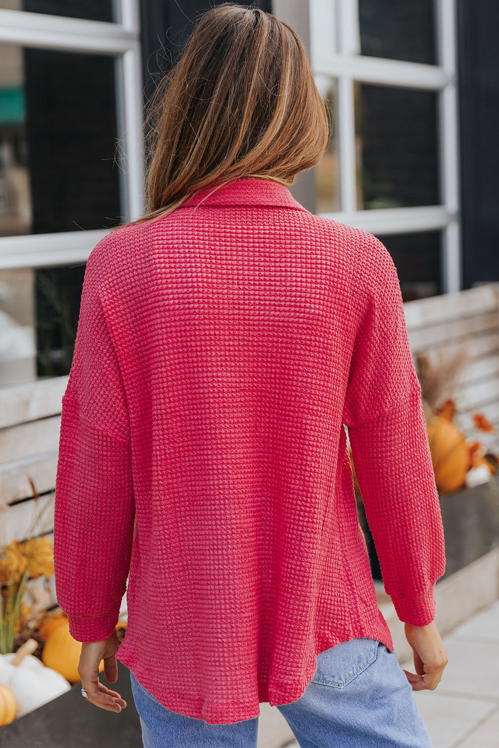 Waffle-knit oversized shirt jacket in strawberry pink with a collared neckline and long sleeves.