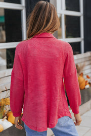 Waffle-knit oversized shirt jacket in strawberry pink with a collared neckline and long sleeves.