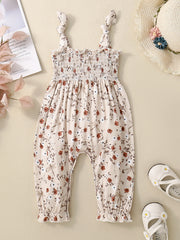 Floral print baby jumpsuit with smocked bodice and tie straps.