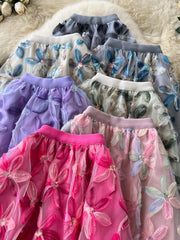 Embroidered floral layered skirt in pink, purple, gray, and blue with sequin details.