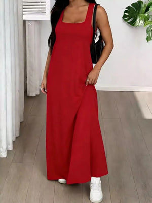 Red scoop neck maxi dress with a slit, styled with sneakers and a crossbody bag.