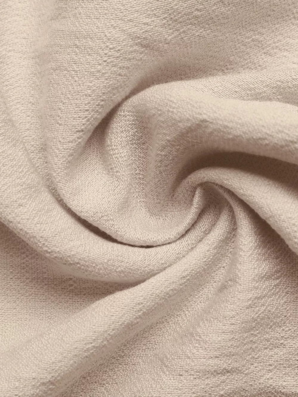 Light beige midi dress fabric detail with textured weave and tie-waist detail.