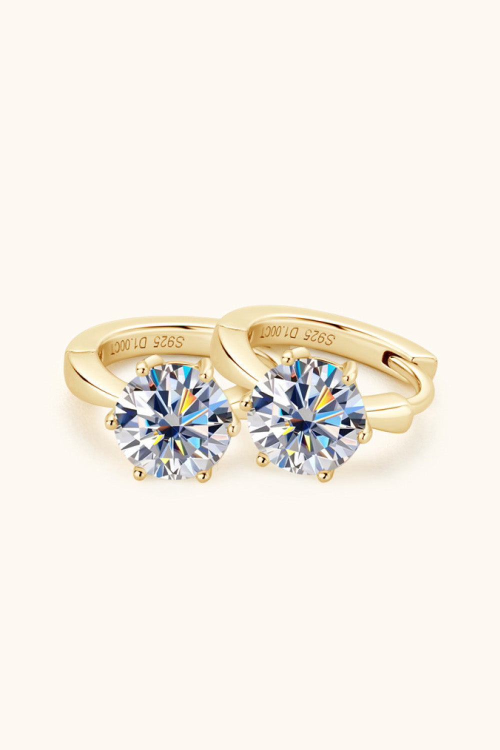 Gold moissanite solitaire huggie hoop earrings with six-prong setting.