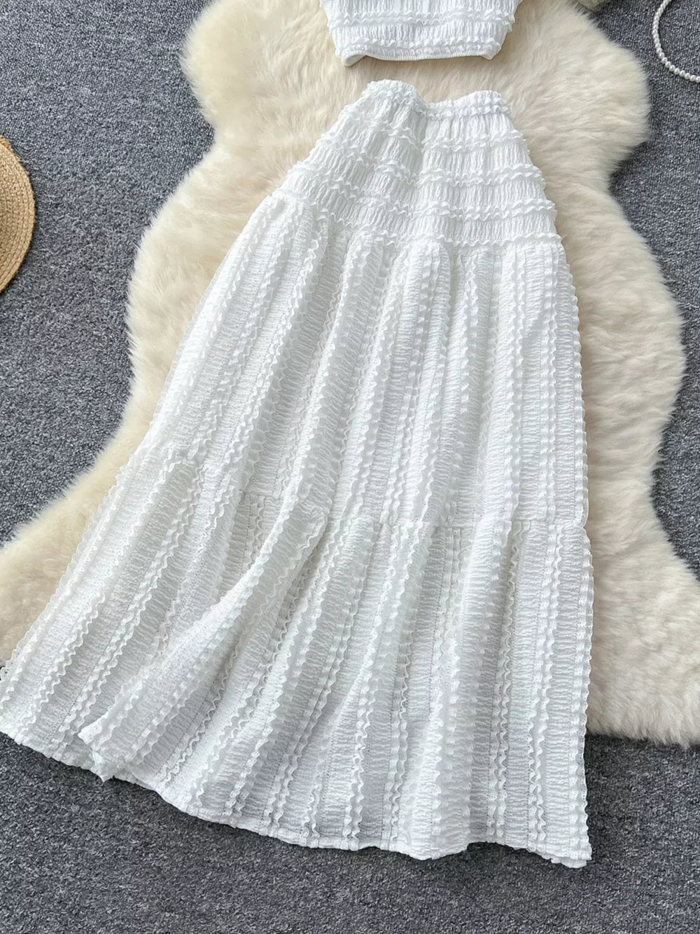 White ruched polyester crop top and maxi skirt set with tiered ruffles.