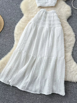 White ruched polyester crop top and maxi skirt set with tiered ruffles.