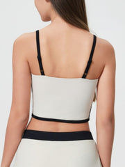 White crop top with black trim and adjustable straps, shown from the back.
