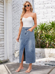 Light blue denim midi skirt with elastic waist and front slit, styled with a white strapless top.