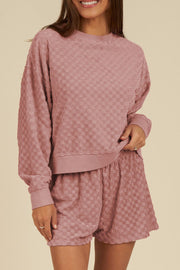 Textured checkered lounge set in dusty pink, featuring a crewneck sweatshirt and shorts.