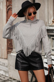 Light gray turtleneck sweater with chevron fringe detail and long sleeves.