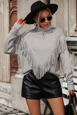 Light gray turtleneck sweater with chevron fringe detail and long sleeves.
