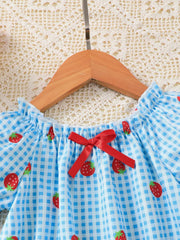 Baby dress with blue gingham and strawberry print, featuring a red bow detail.