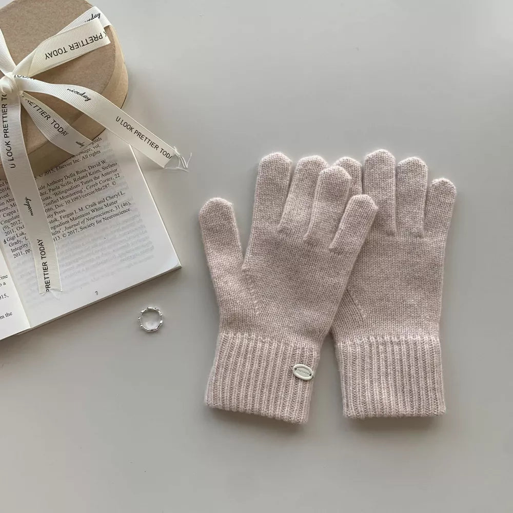 Luxurious wool knit gloves in beige with ribbed cuffs and a small logo detail.