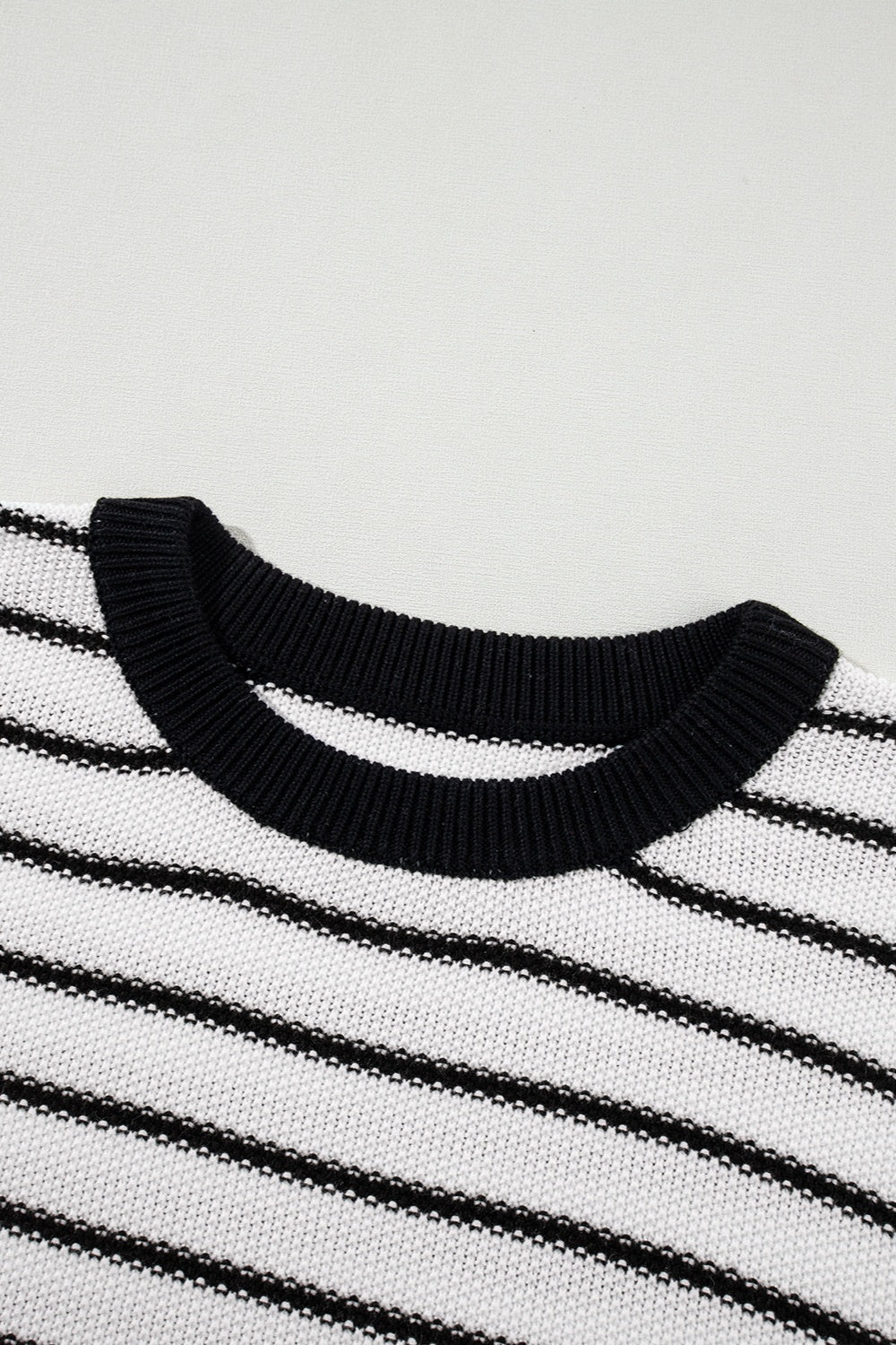 Black and cream striped knit sweater with contrast trim neckline.