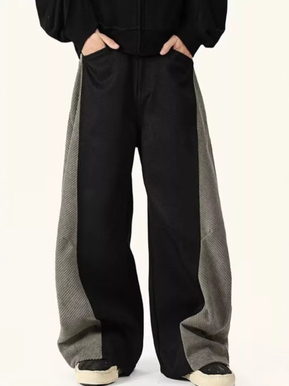 Men's black sweatpants with grey contrast panels and relaxed fit