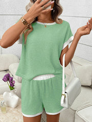 Light green ribbed knit two-piece set with white trim, short sleeves, elastic waistband shorts with pockets.