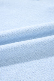 Sky blue knit sweater with embroidered floral detail and notch neck.