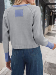 Gray raglan sleeve knit cardigan with blue accents and patch detail