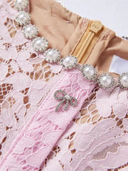 Powder lace dress with pearl and rhinestone neckline detail and bow brooch.