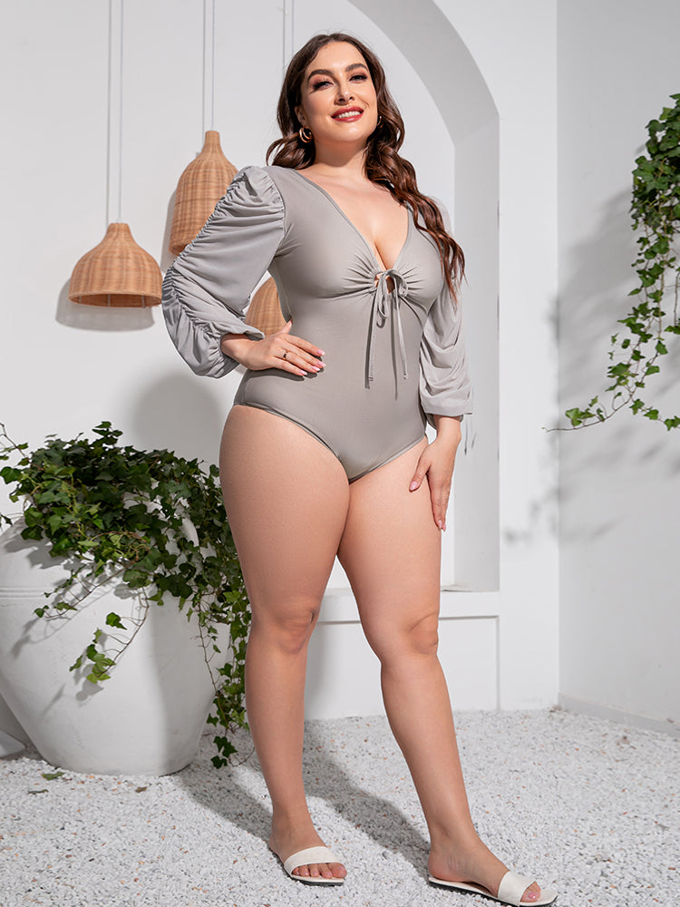 Light gray one-piece swimsuit with tie-front and ruched balloon sleeves.