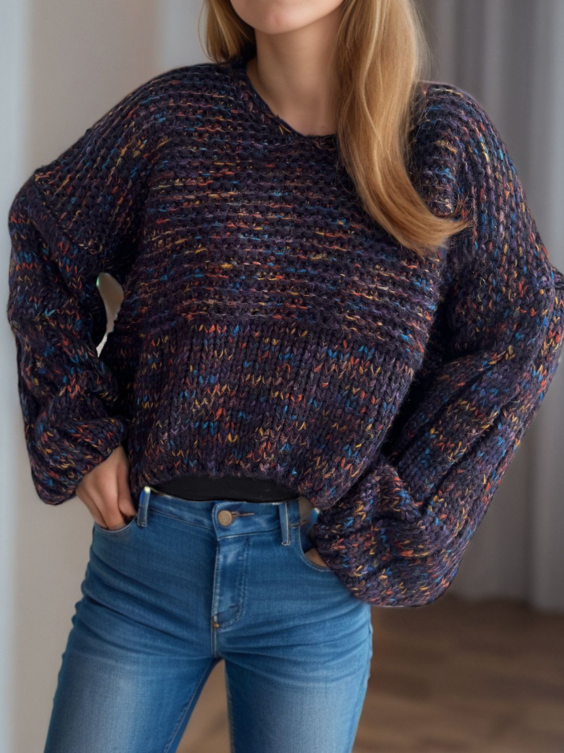 Textured knit sweater in dark blue with multicolor flecks, featuring balloon sleeves and a V-neck.