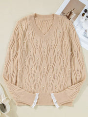 Beige V-neck knit sweater with pearl details and lace trim cuffs.