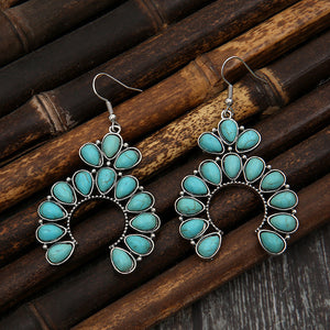 Teal crescent dangle earrings with multiple teardrop stones and silver alloy setting.