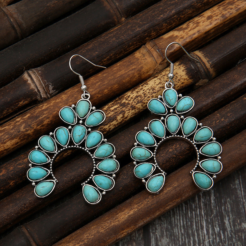 Teal crescent dangle earrings with multiple teardrop stones and silver alloy setting.