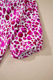 Vibrant leopard print V-neck blouse with short puff sleeves and elastic cuffs.